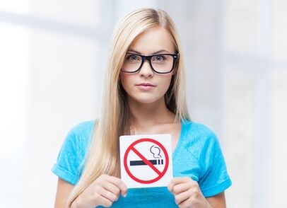 dievča držiace znak zákazu fajčenia vo vchode